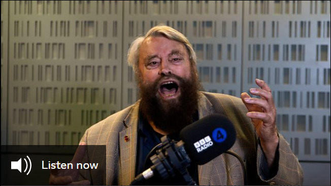 Brian Blessed, a bearded man, stands speaking in front of a microphone branded with the BBC Radio 4 logo. A button reads 'listen now'